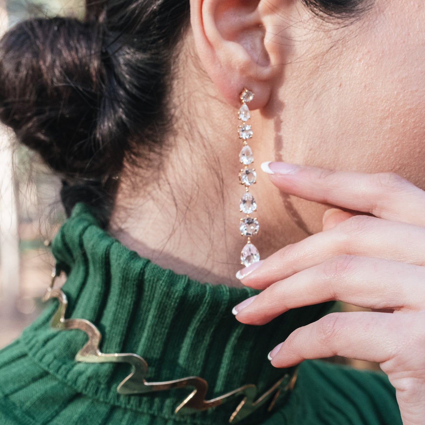 Model wearing white topaz earrings in yellow gold vermeil
