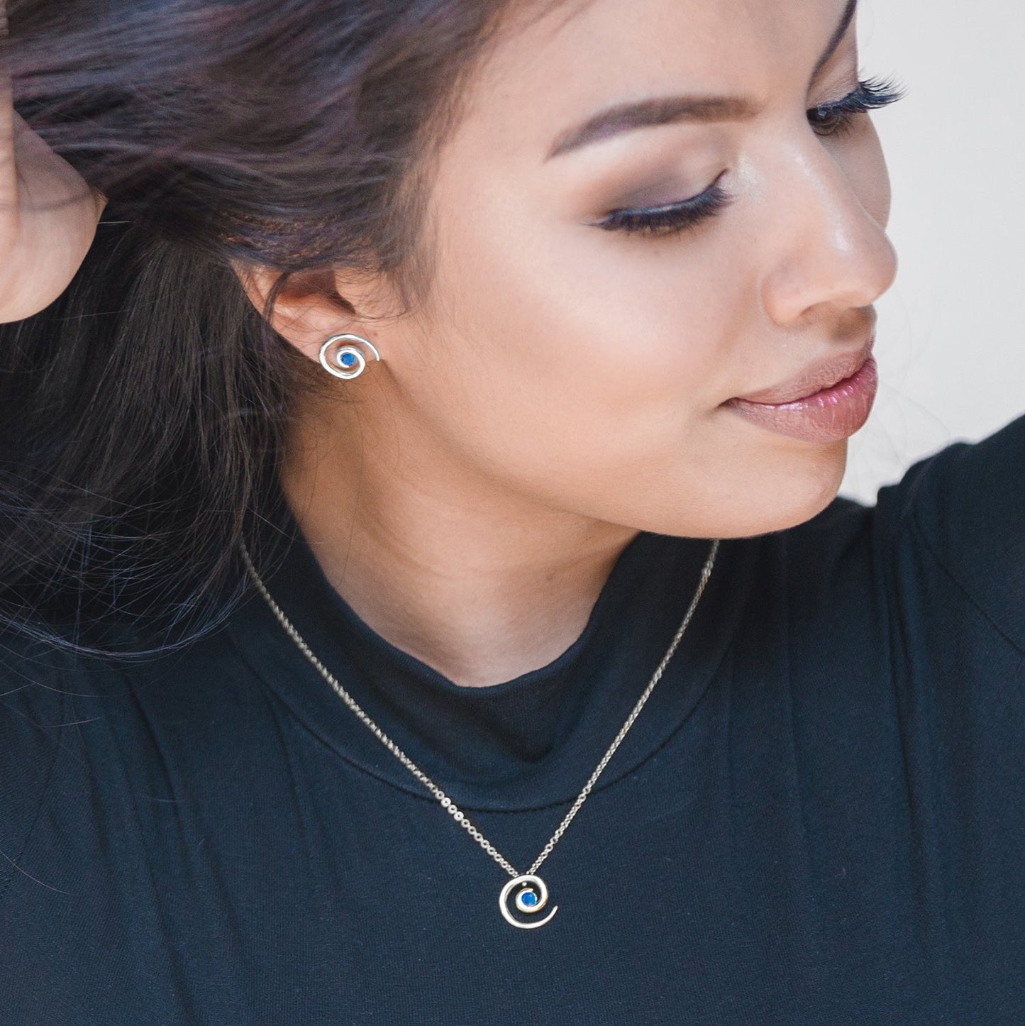 Model wearing silver vermeil spiral sapphire necklace