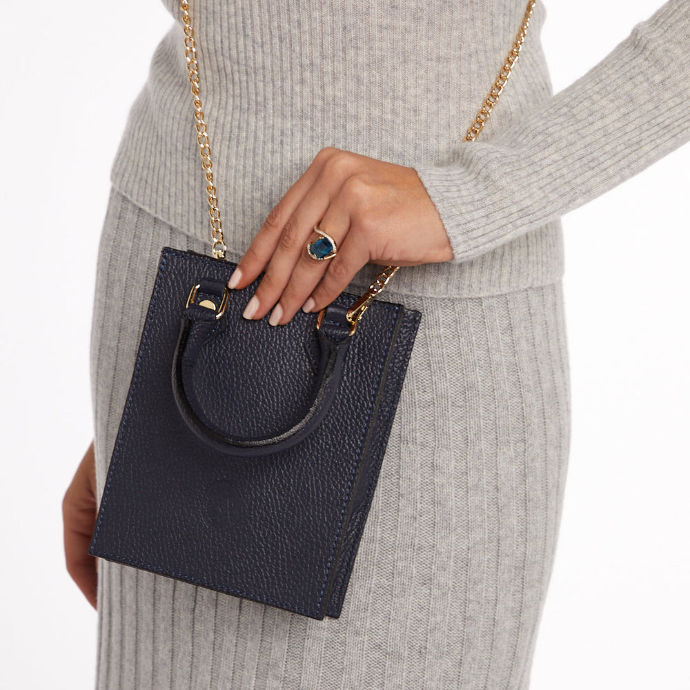 
                  
                    Model holding small navy blue bag
                  
                