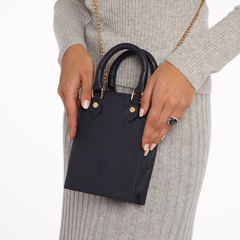 
                  
                    Model holding small navy blue bag
                  
                