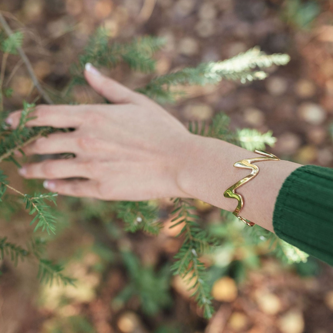 Close up of Model demonstrating the wear of the luxury gold jewelry - 18ct Yellow Gold plated Sterling Silver Wedeln Bangle – Gstaad Collection, Augustine jewelry, Luxury jewelry London.