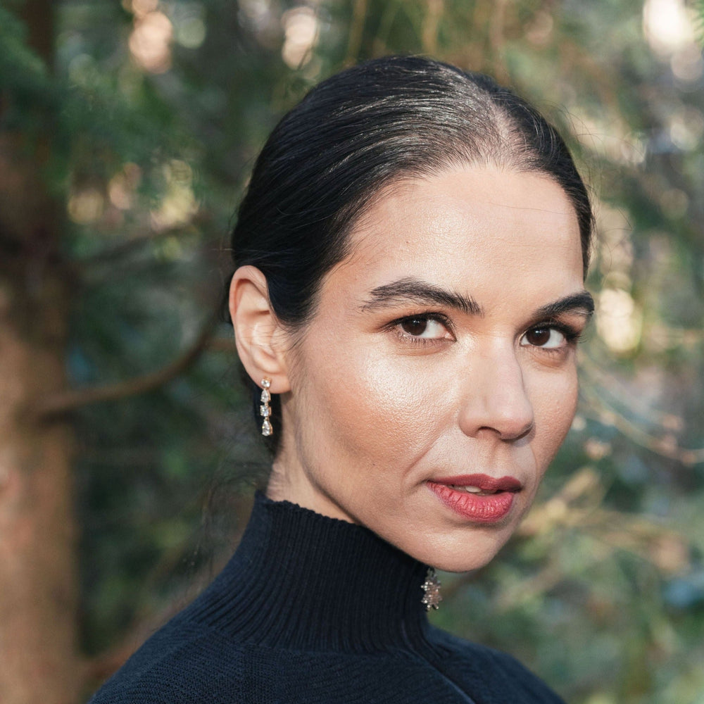 Model wearing short white topaz yellow gold drop earrings