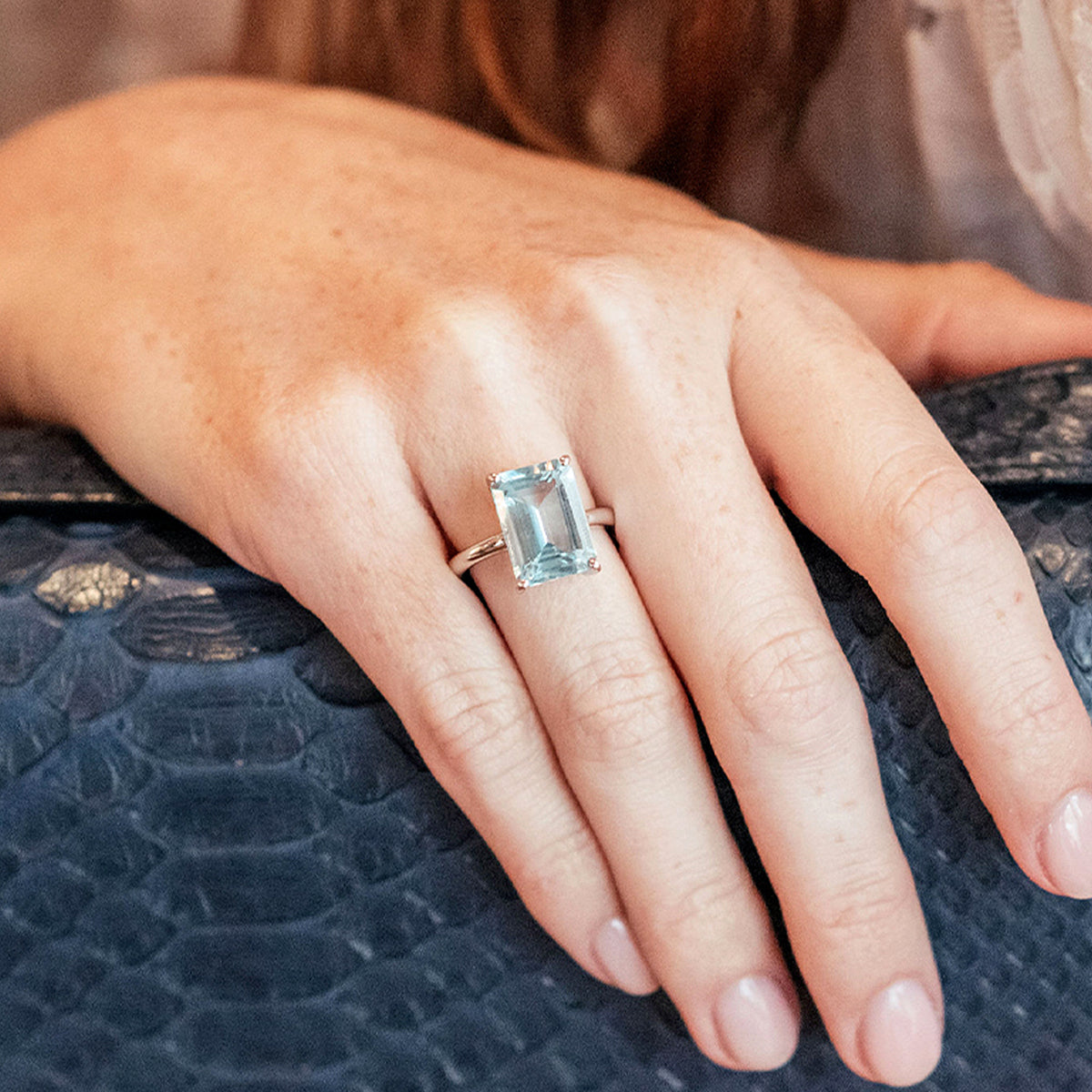 Elegant aquamarine and white gold ring from the South of France Collection by Augustine Jewels, worn with a lace sleeve and paired with a navy snakeskin handbag